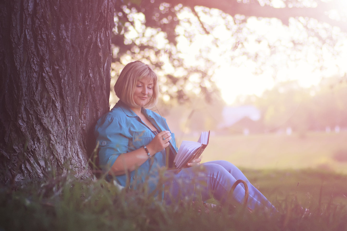 woman reading beneath tree