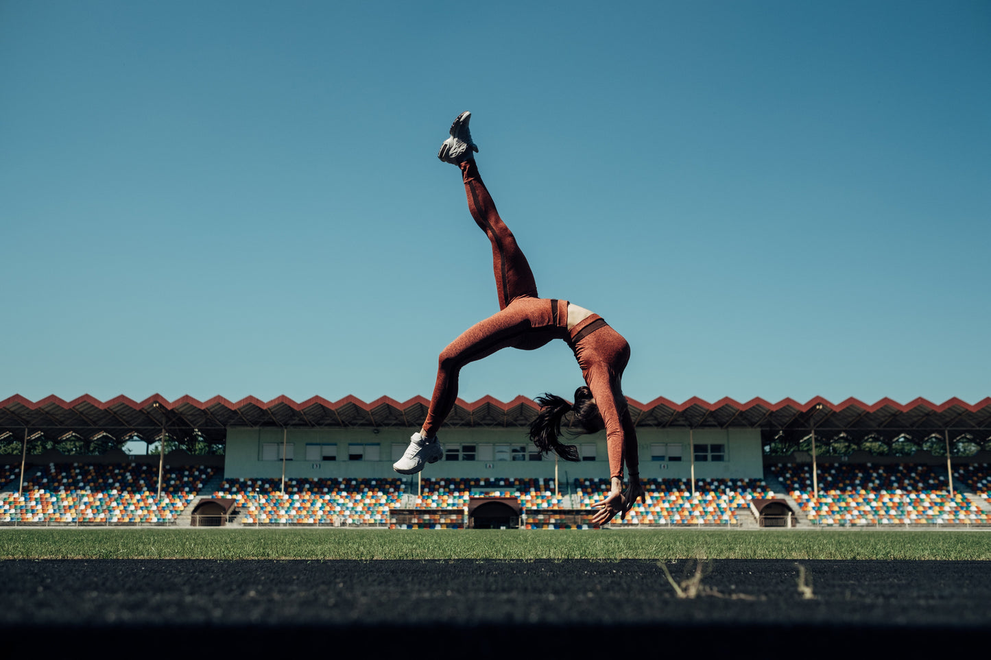woman completes gymnastic move outdoors