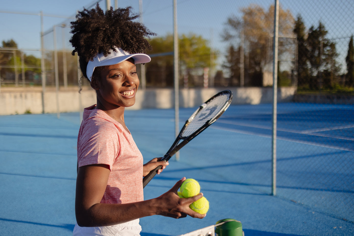 woman smiling and playing tennis