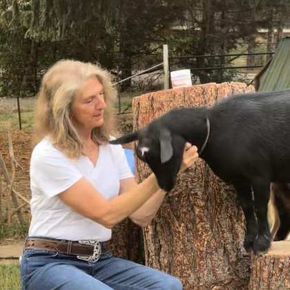Lisa on her farm with one of the goats.